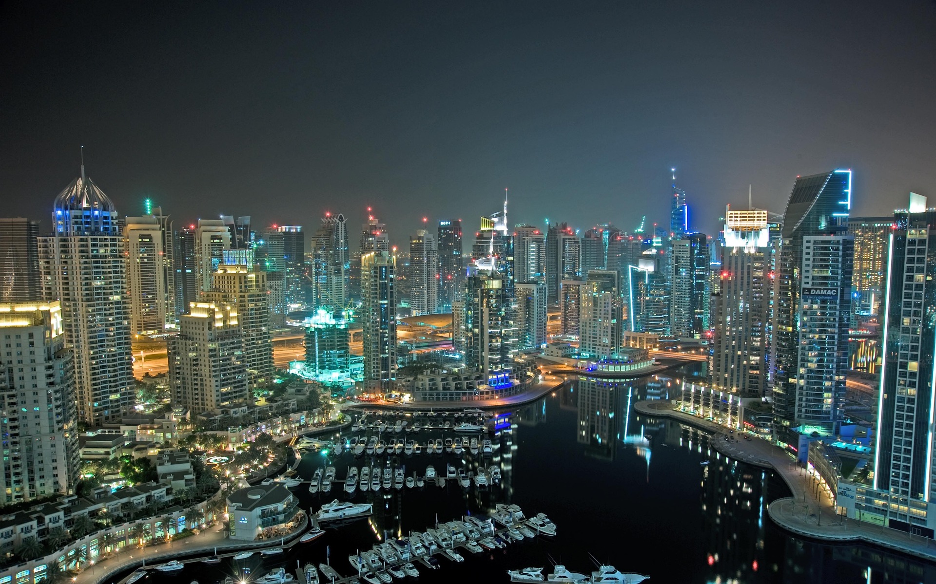 Dubai Marina at night with illuminated towers and yachts on the water
